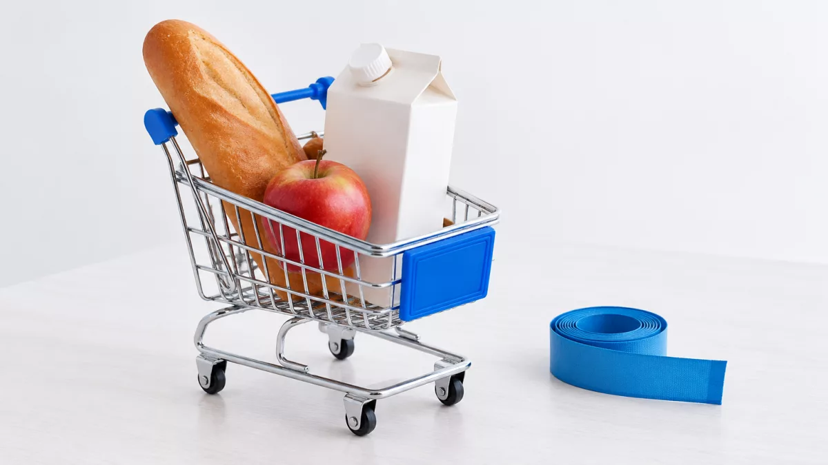 Магазинная тележка с продуктами и синяя мерная лента